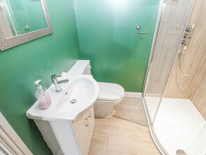 Un baño con lavamanos, inodoro y ducha blancos.