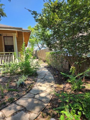 A stone pathway leading to a house with a porch. - Cute & Quiet Garage Apt Home (Houston)