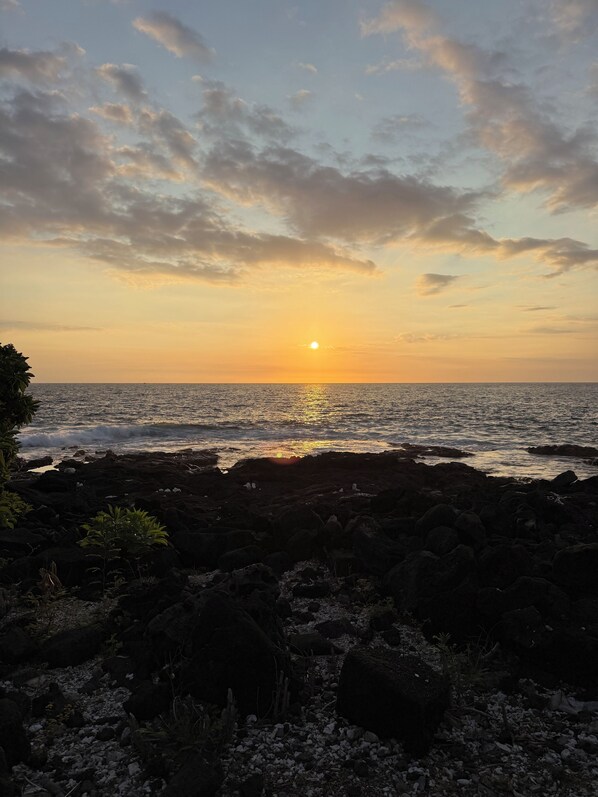A sunset over a rocky coastline with the sun setting on the horizon. - Upgraded 2 Bed/2 Bath oceanfront property at the Royal Sea Cliff Central A/C (Kailua-Kona)