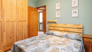 A bedroom with a bed, wooden wardrobe, and framed artwork on the wall. - San Concordio Blue -Affitti Brevi Italia (Lucca)