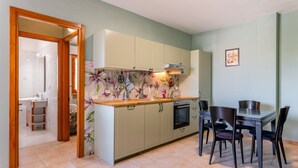 A compact kitchen with a dining area, featuring a wooden countertop, a built-in oven, and a small sink. - San Concordio Blue -Affitti Brevi Italia (Lucca)