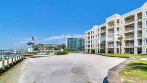 Ein Strandhotel mit mehreren Balkonen, einer Marina und einem strahlend blauen Himmel.