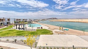 Un complexe hôtelier moderne doté d’une piscine, d’un espace extérieur aménagé et offrant une vue sur un lac.