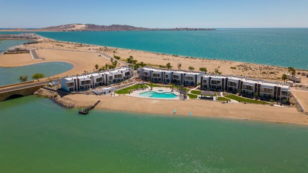 Ein Küstenhotel mit Pool, direkt am Strand, und einer Brücke zur Anbindung an das Festland.
