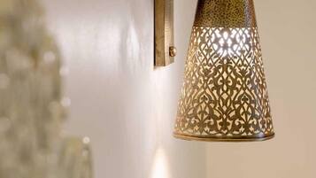 Luminária de latão fixada na parede, com desenhos recortados elaborados.
