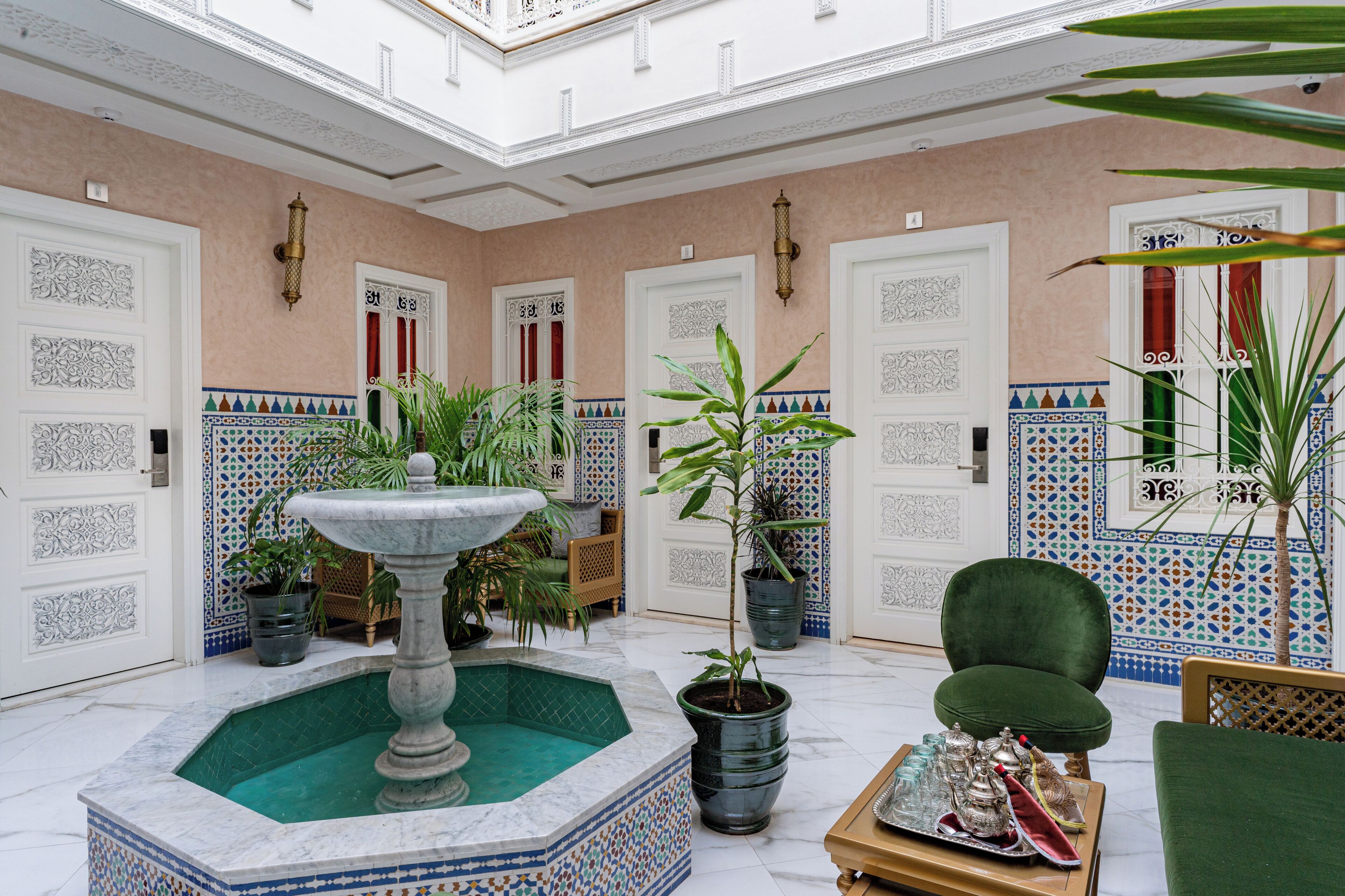A luxurious interior with a central fountain, tiled walls, and a seating area.