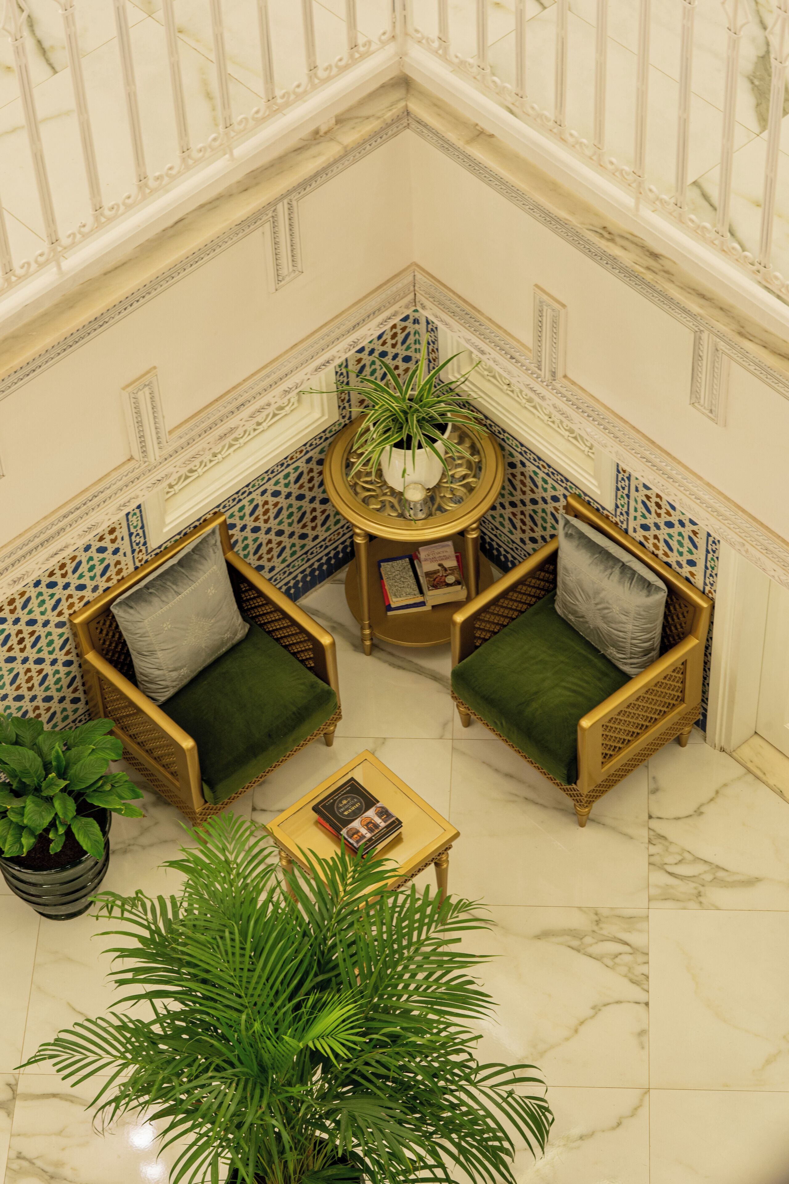 A corner seating area with two wicker chairs, a small table, and a potted plant.