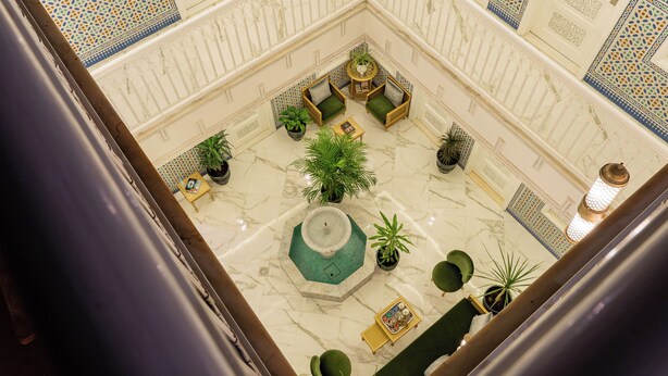 A spacious lobby with a fountain, seating area, and potted plants. - Hotel Riad Chami (Marrakech)