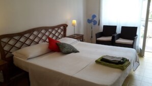 A hotel room with a bed, a nightstand, a lamp, two chairs, and a window. - Panoramic penthouse a few meters from the sea and the promenade of Terracina (Terracina)