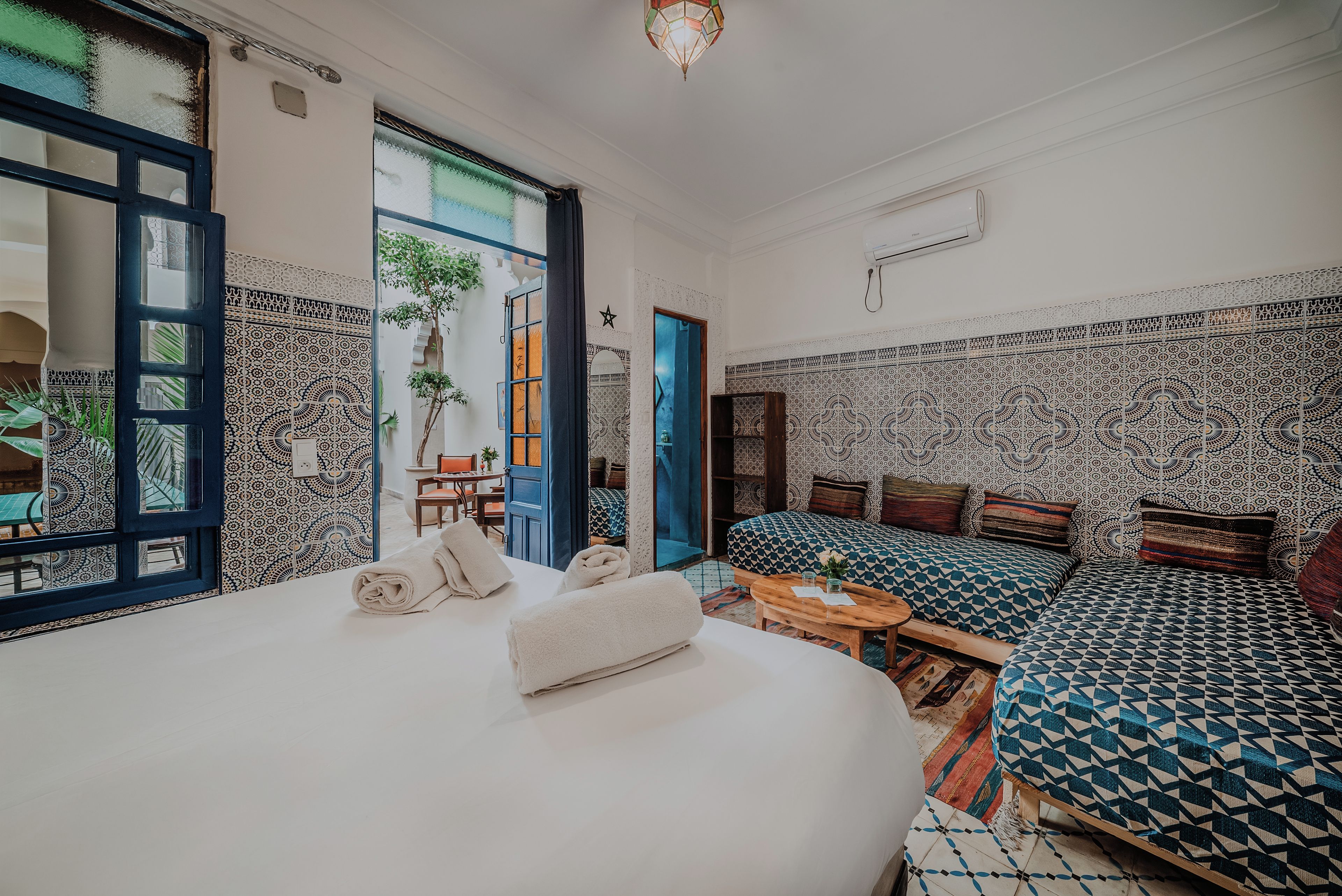 Une chambre d’hôtel avec un grand lit, un canapé, une petite table et une vue sur l’extérieur.