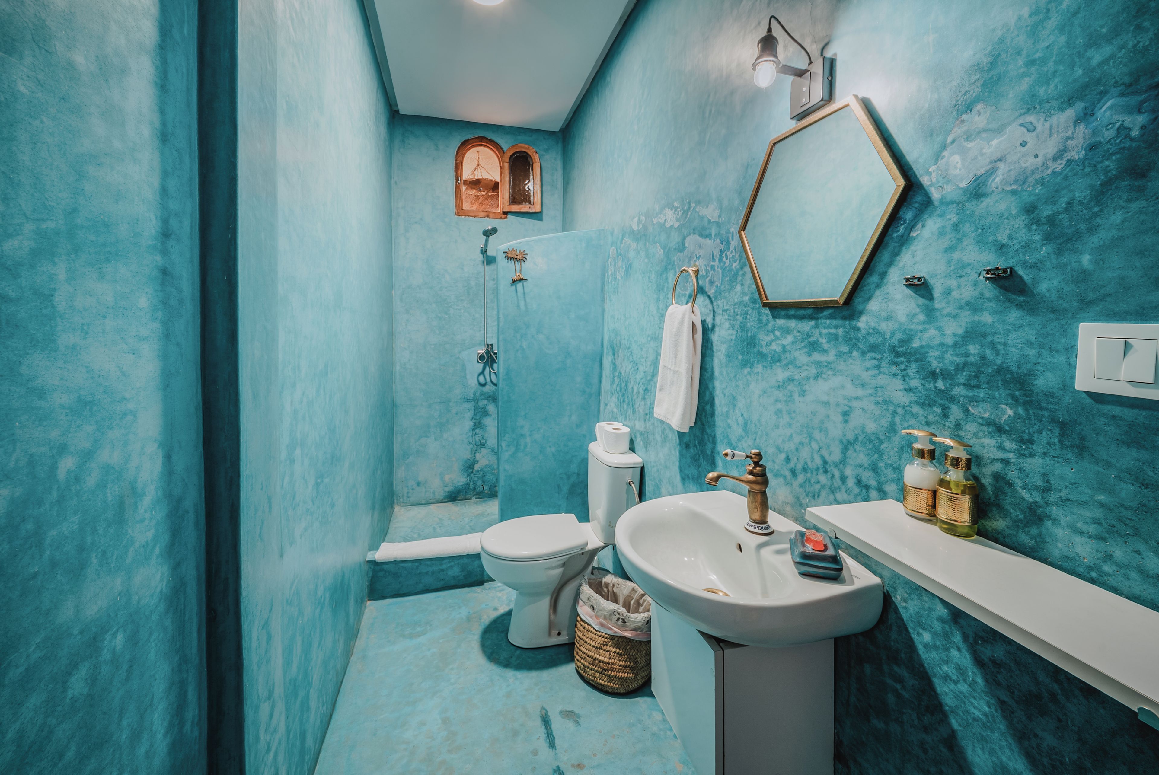 A bathroom with a shower, toilet, sink, and a mirror.