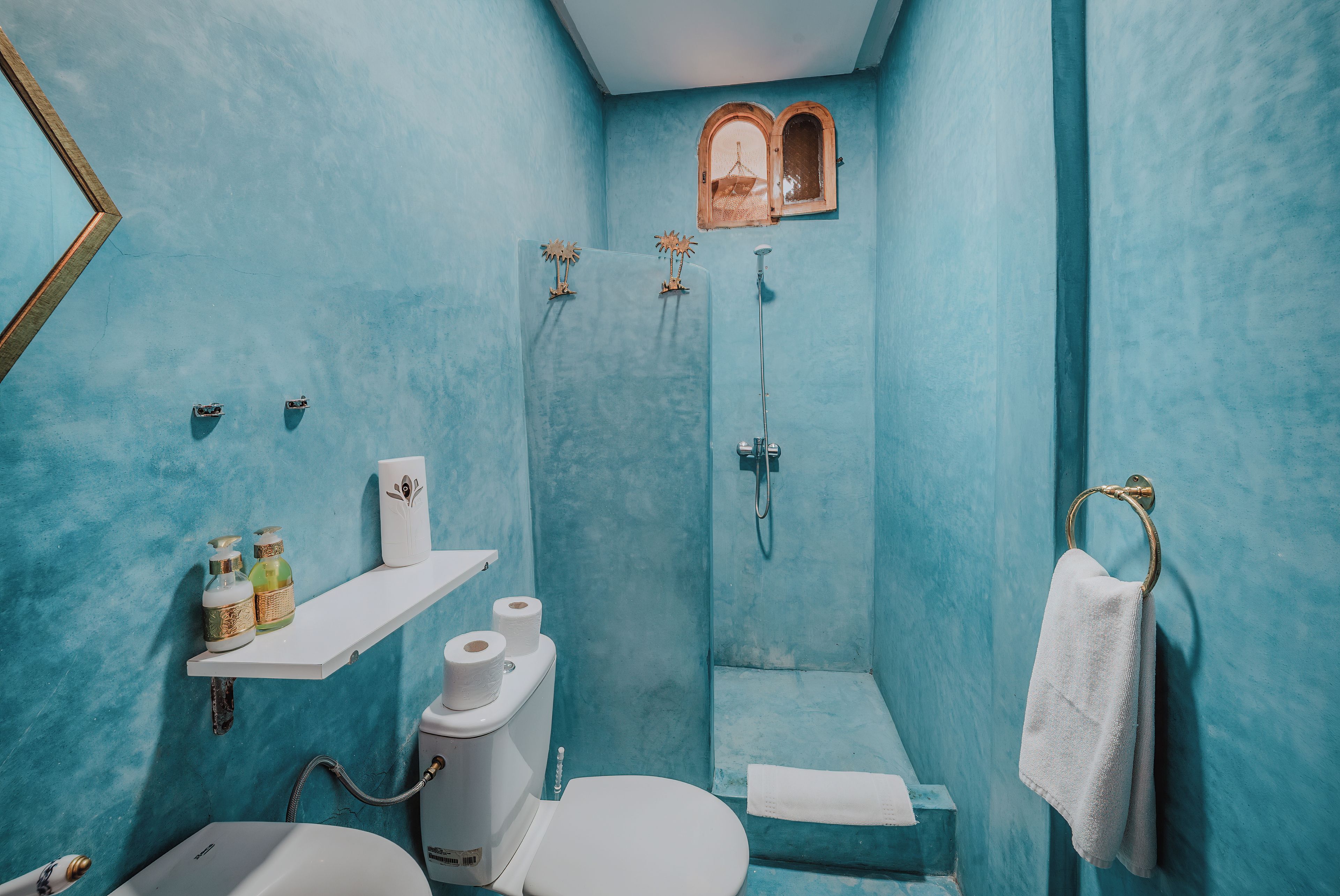 Une salle de bain équipée de toilettes, d’un lavabo, d’une douche et d’un porte-serviettes.