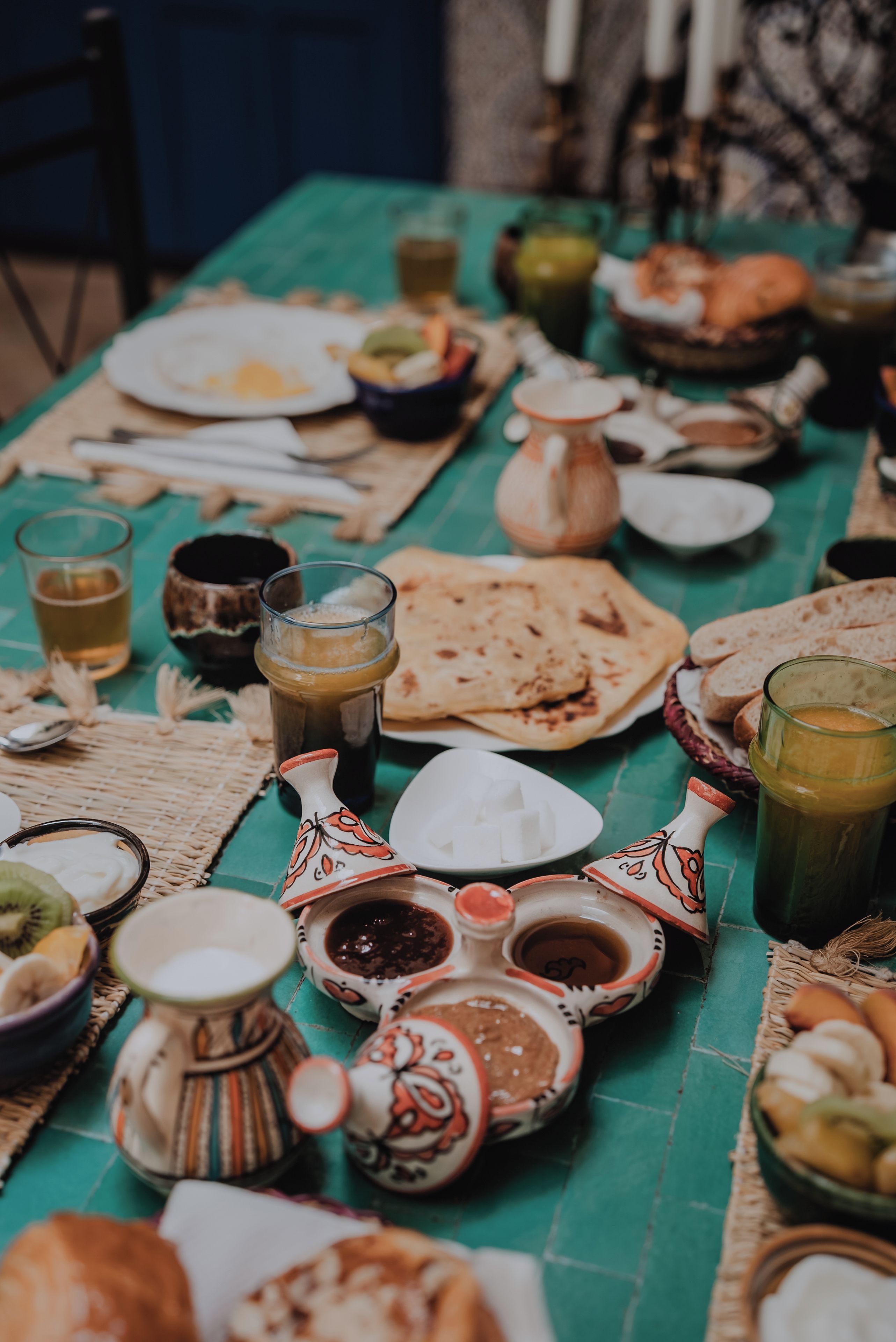Une table dressée avec différents plats, verres et couverts, ce qui laisse supposer qu’un repas va être servi.