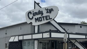 A motel named 'Cindy Lyn' with a distinctive sign, a visible entrance, and a fire hydrant in the foreground. - Cindy Lyn Motel (Cicero)
