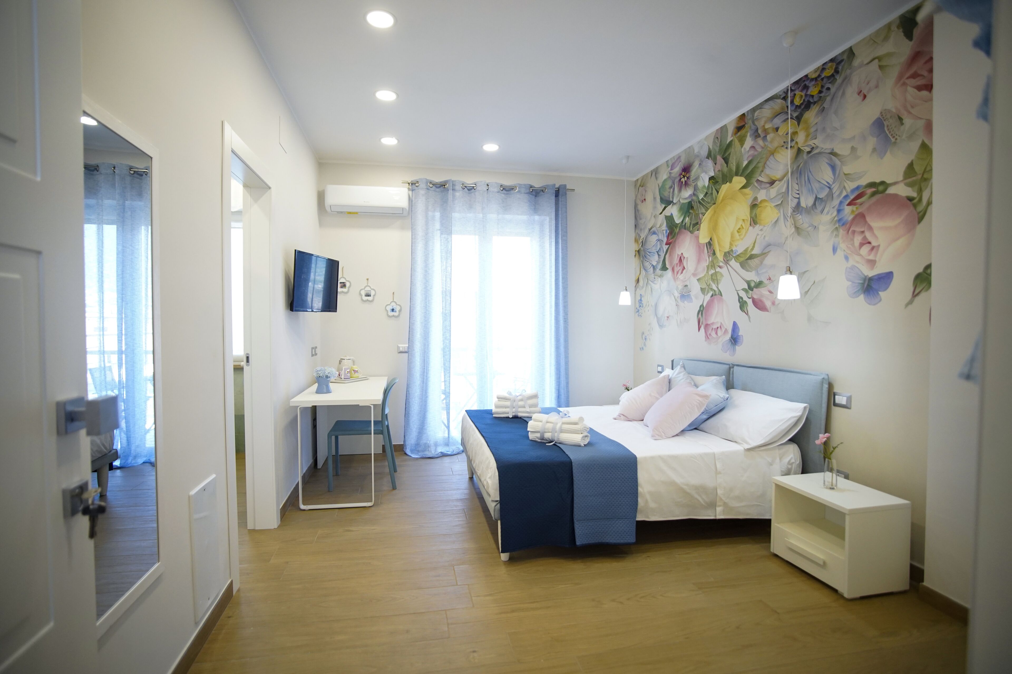 Une chambre à coucher comprenant un lit, une table de chevet et un bureau avec une chaise.