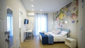 Ein Schlafzimmer mit einem Bett, einem Nachttisch und einem Schreibtisch mit Stuhl.