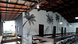 A room with a patterned floor, wooden railings, and a ceiling with exposed beams. - Toca do pato hospedagem (Paraty)
