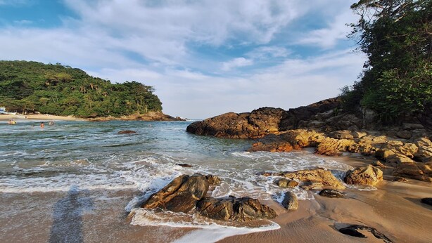A beach with rocky formations and clear water. - Toca do pato hospedagem (Paraty)