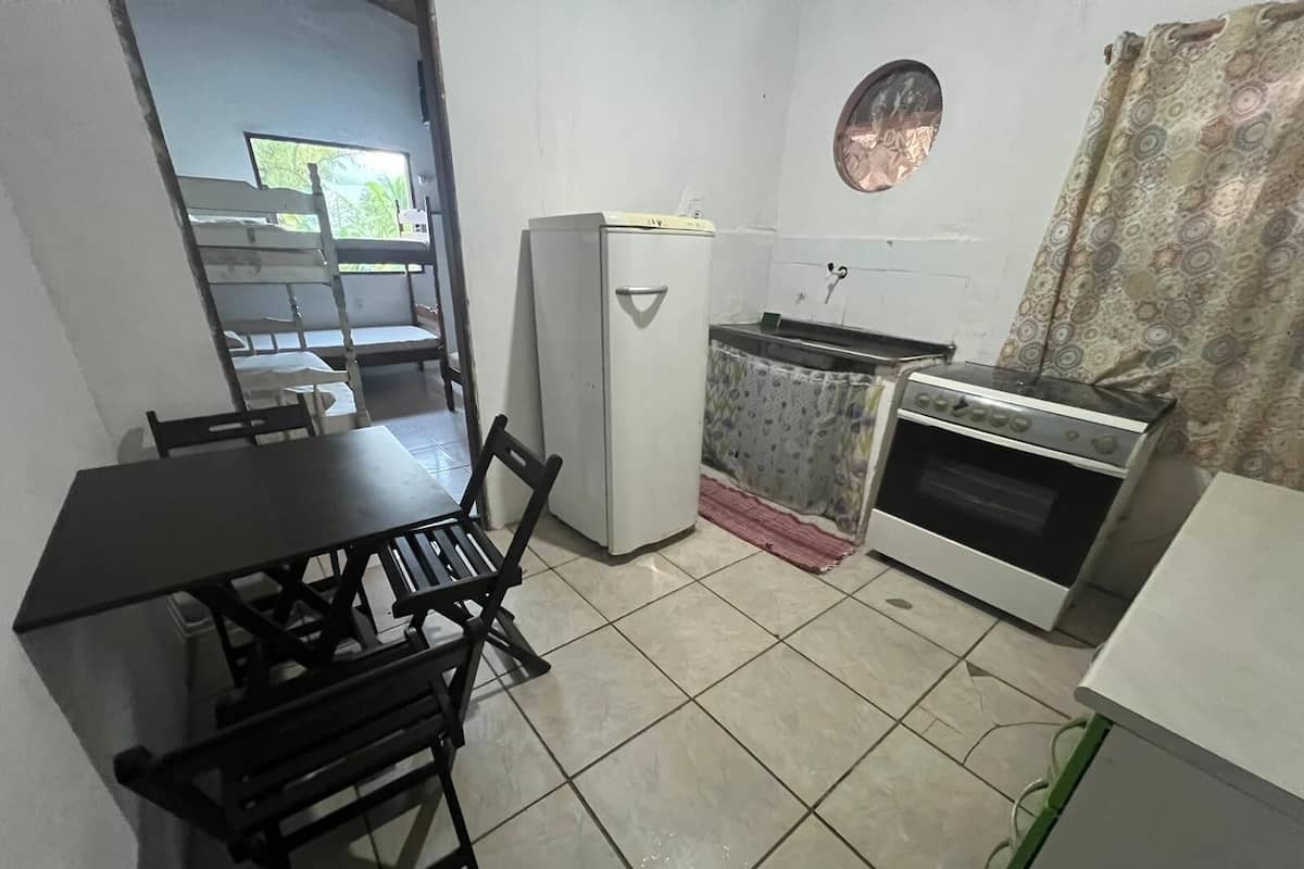 Enjoy meals in this kitchen with a dining table and chairs, a refrigerator, and a stove with oven.