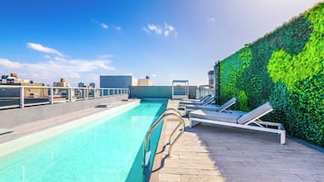Una piscina al aire libre de temporada, sillones reclinables de piscina