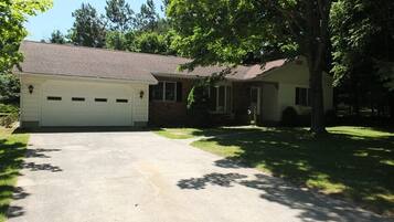 A two-story house with a garage, a driveway, and a lawn.