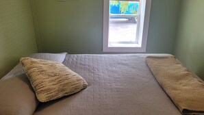 Ein Schlafzimmer mit einem Einzelbett, einem Fenster und einer Wandcollage mit Fotos.
