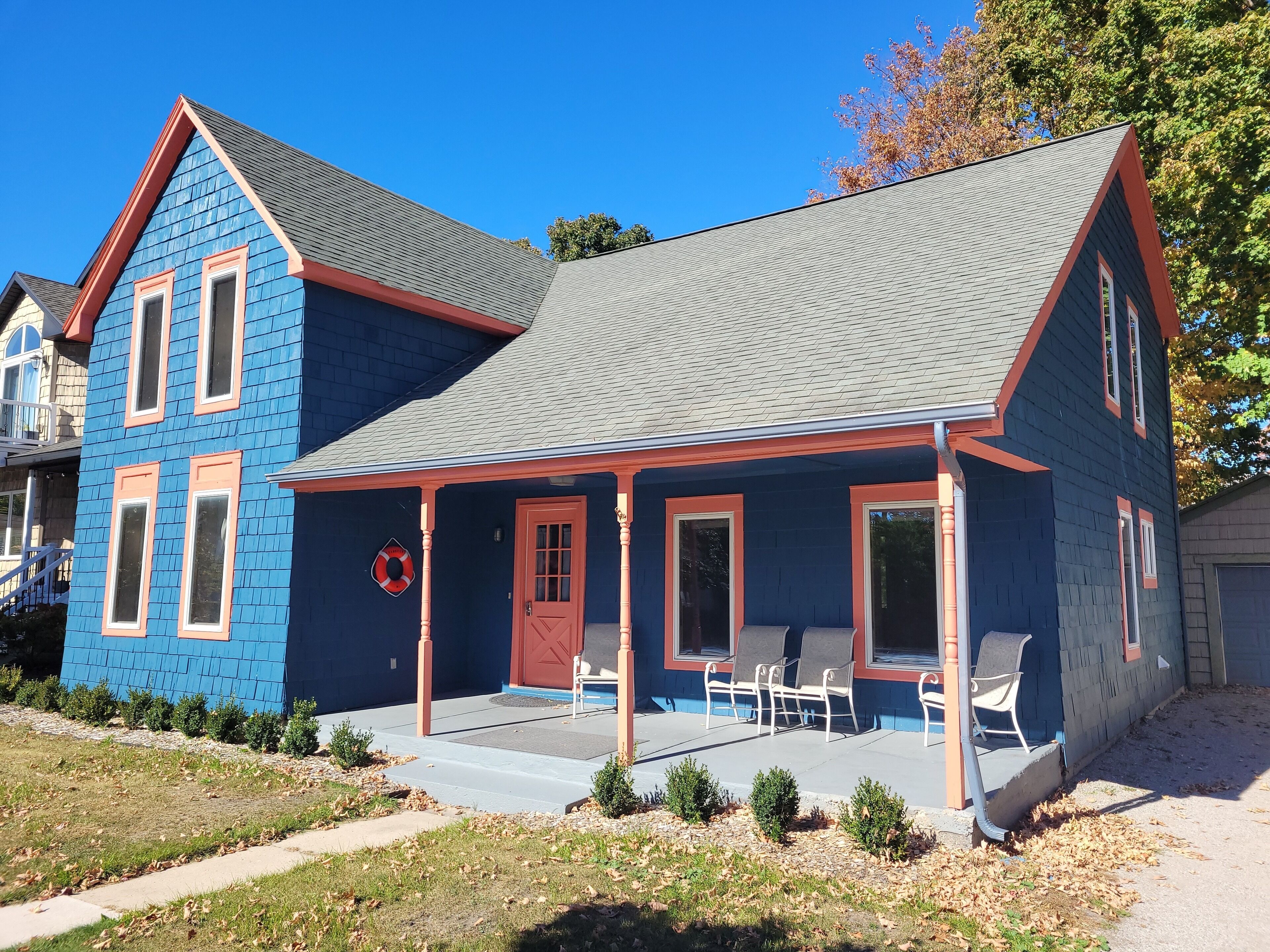 A two-story house with a blue exterior and a grey roof.