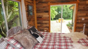 Une chambre à coucher avec un lit, une fenêtre et une porte donnant sur l’extérieur.