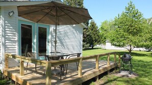 A wooden deck with outdoor furniture and a grill. - Beach Town Escape - NEWLY-REMODELED & GORGEOUS!  GREAT LOCATION AS WELL! (Frankfort)
