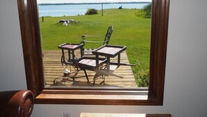 A window with a view of a deck featuring outdoor furniture and a grassy area. - Malabar Cove - LAKEFRONT, QUIET, & RELAXING!  INCLUDES A/C AND KAYAKS! (Gladstone)