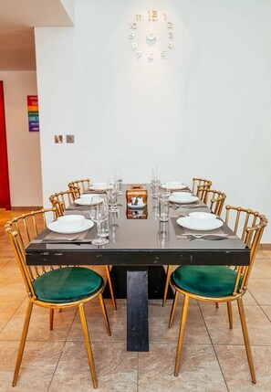 A dining table with eight chairs, each with a green cushion, set for a meal. - 2 Bedroom Cozy Apartment in Palm Jumeirah (Dubai)