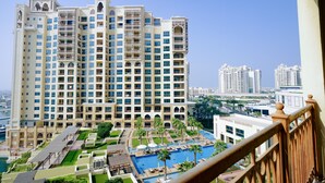 Un hôtel de grande hauteur doté de nombreux balcons, d’une piscine et offrant une vue sur le paysage urbain environnant.