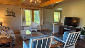 A living room with a sofa, chairs, a coffee table, a TV, and a fireplace. - The "Barn Loft" (Southwest Harbor)
