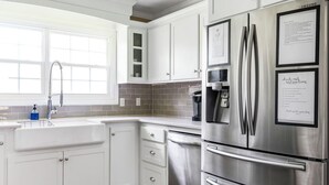 A modern kitchen with white cabinets, a stainless steel refrigerator, and a window above the sink. - Charming Rancher, Close to Everything! (Joplin)