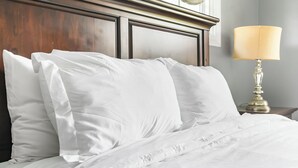 A neatly made bed with white linens and a wooden headboard. - Charming Rancher, Close to Everything! (Joplin)