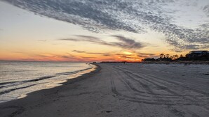 Una playa con cielo despejado y un atardecer.