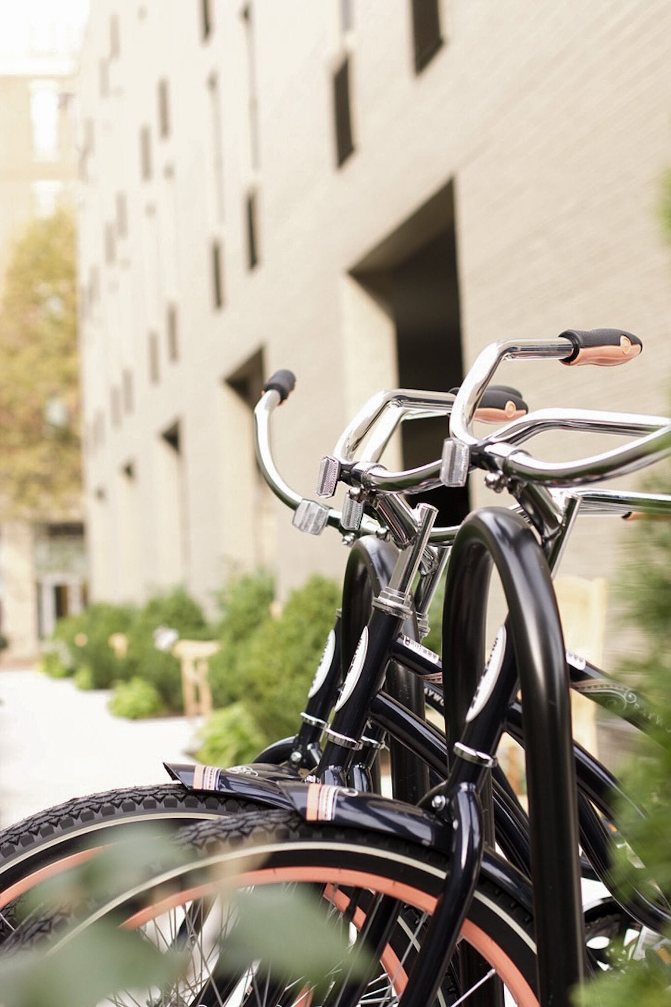 A bicycle parked in front of a building with a brick facade and multiple windows.