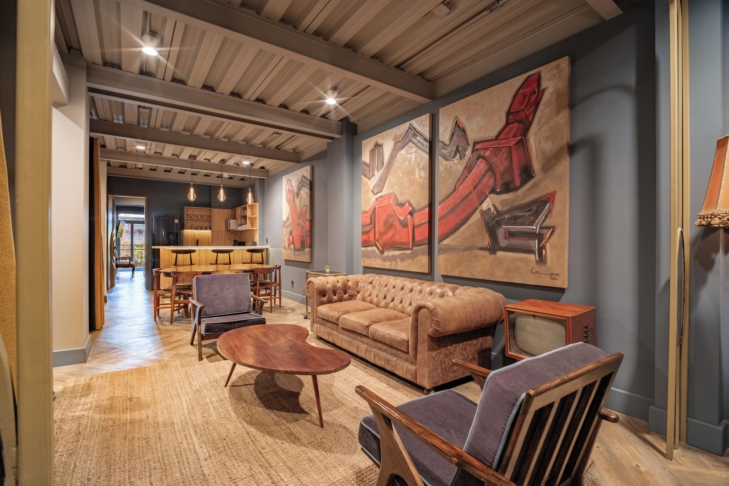 A cozy living area with a sofa, chairs, a coffee table, and artwork on the walls.