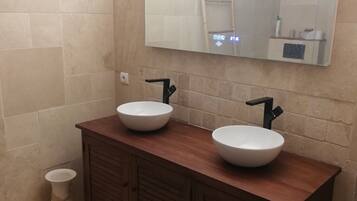 Een douche, handdoeken, shampoo, toiletpapier