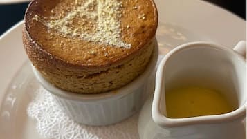 Dessert auf einem Teller mit einer kleinen Schale Sirup.