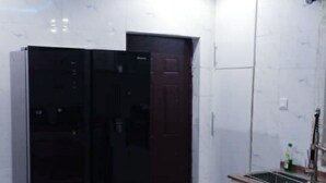 A kitchen with a marble countertop, a black refrigerator, and white tiled walls. - Spacious 3 bedroom  Apartment,  All room ensuite , Ipaja Lagos (Lagos)
