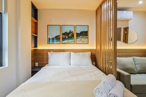 A hotel room with a bed, a sofa, and three framed pictures on the wall. - 360 Rio Santos Dumont (Rio de Janeiro)