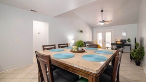 A dining area with a large table, chairs, and a ceiling fan. - Gainesville Cozy Pet friendly Near UF & Downtown (Gainesville)