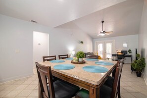 A dining area with a large table, chairs, and a ceiling fan. - Gainesville Cozy Pet friendly Near UF & Downtown (Gainesville)