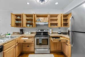 A kitchen with wooden cabinets, stainless steel appliances, and a granite countertop. - Gainesville Nook Room (Gainesville)