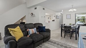 Een moderne woonkamer met een bank, een eettafel en stoelen.