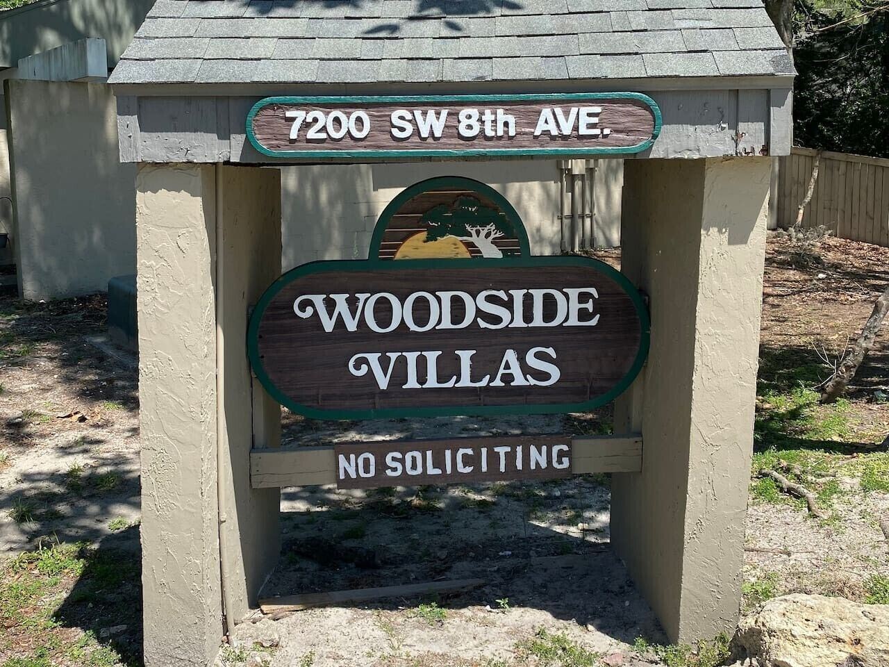 Ein Schild mit der Aufschrift 'Woodside Villas' und einem Verbotsschild für unangekündigte Werbung.