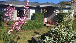 A residential house with a well-maintained garden, a hedge, and a variety of plants. - Starfish -Trinidad Ocean Ave - Couples Haven (Trinidad)