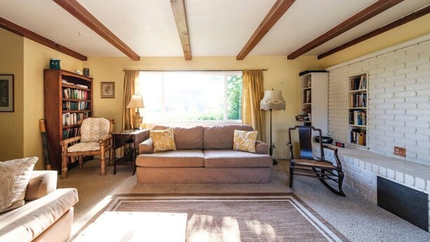 A living room with a sofa, armchairs, a bookshelf, a fireplace, and a window with curtains. - Starfish -Trinidad Ocean Ave - Couples Haven (Trinidad)