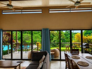 A spacious living area with a large sliding glass door leading to a pool and garden. - Modern villa with stunning jungle views (Provincia de Puntarenas)